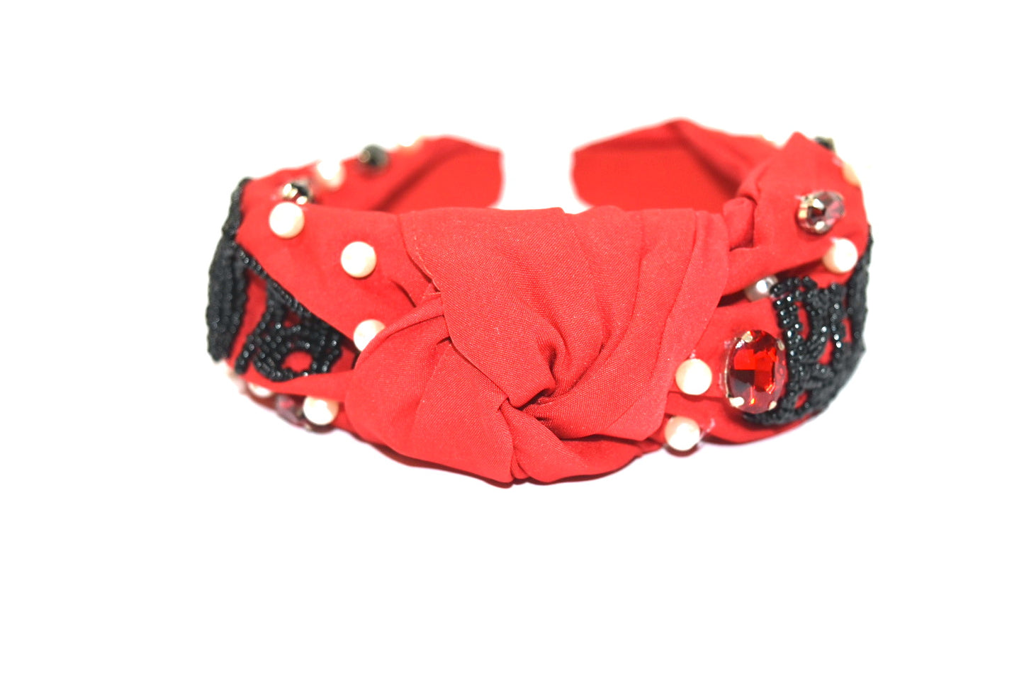 Red headband with black beaded "bulldog" lettering, crystals, and pearls. Top view.