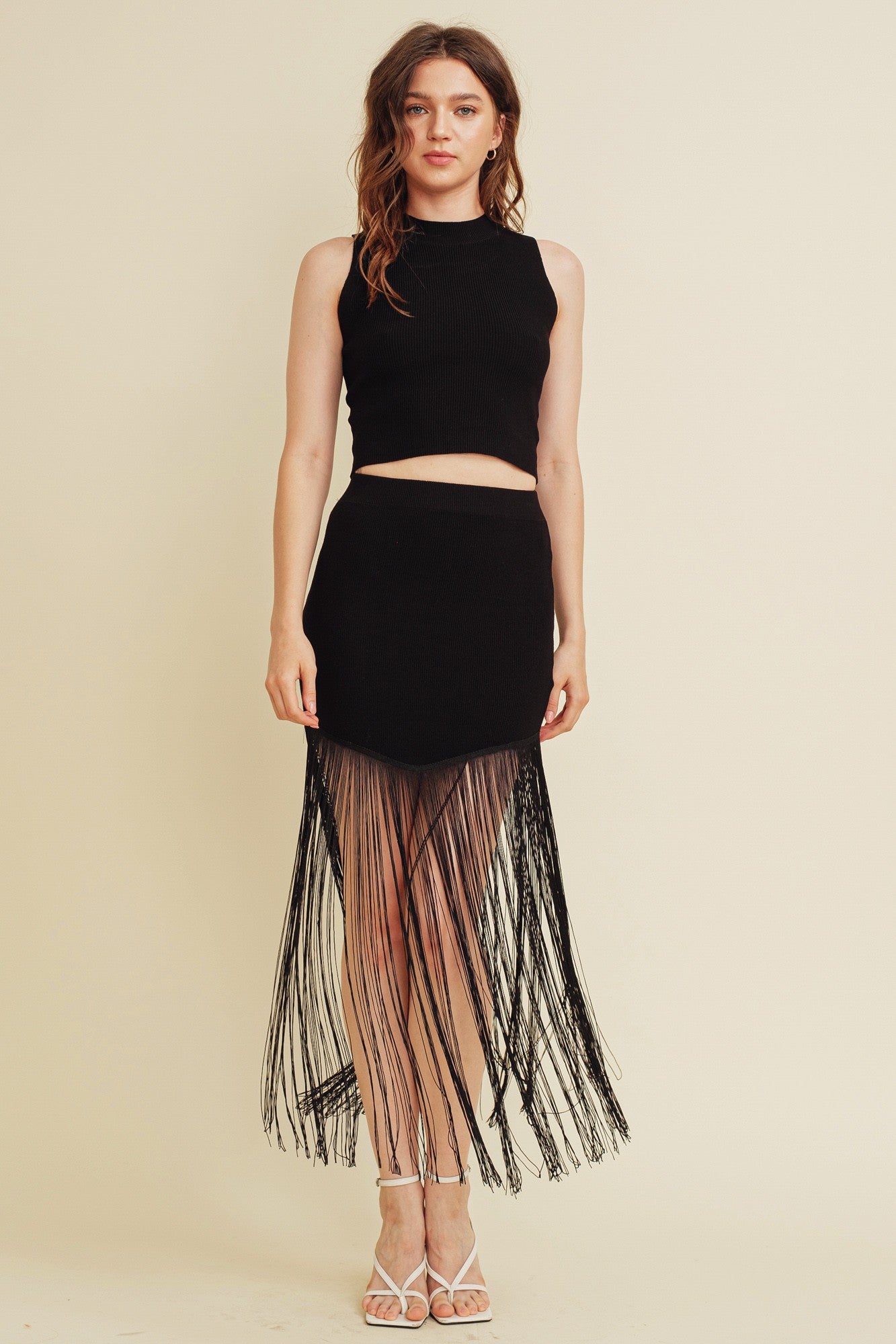 Sleeveless knit top and midi skirt in black with fringe detailing.  Front view.