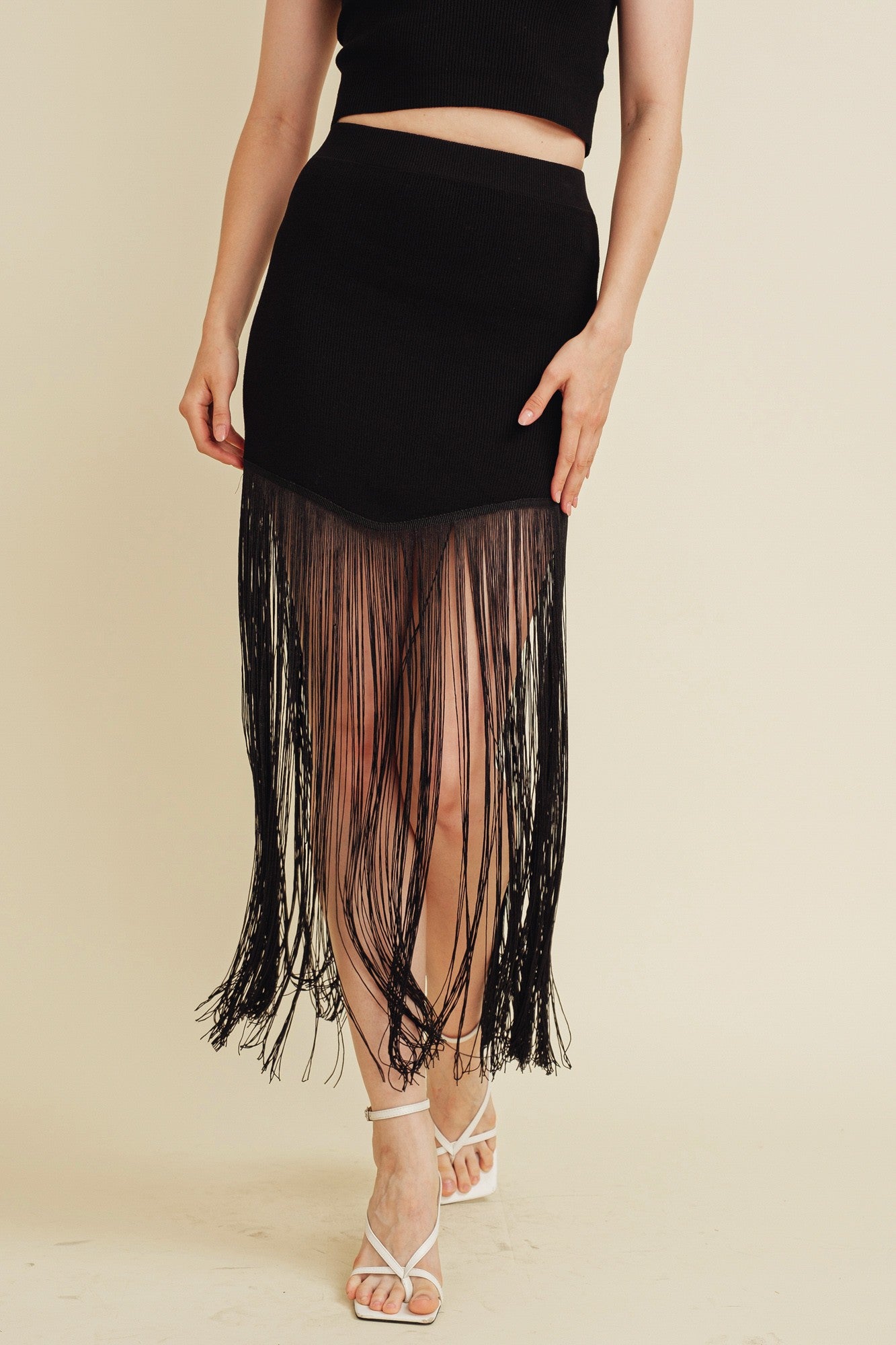 Sleeveless knit top and midi skirt in black with fringe detailing.  Bottom view.