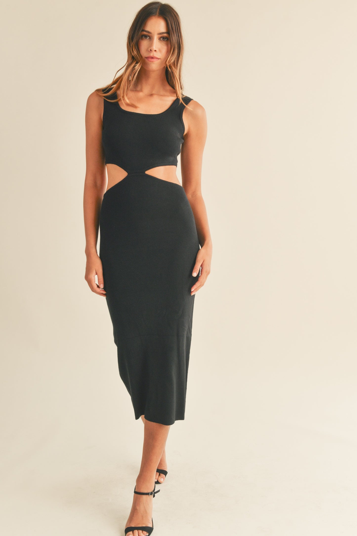 Knit sleeveless midi dress in black features side cut outs and a tank-style top. Front view.