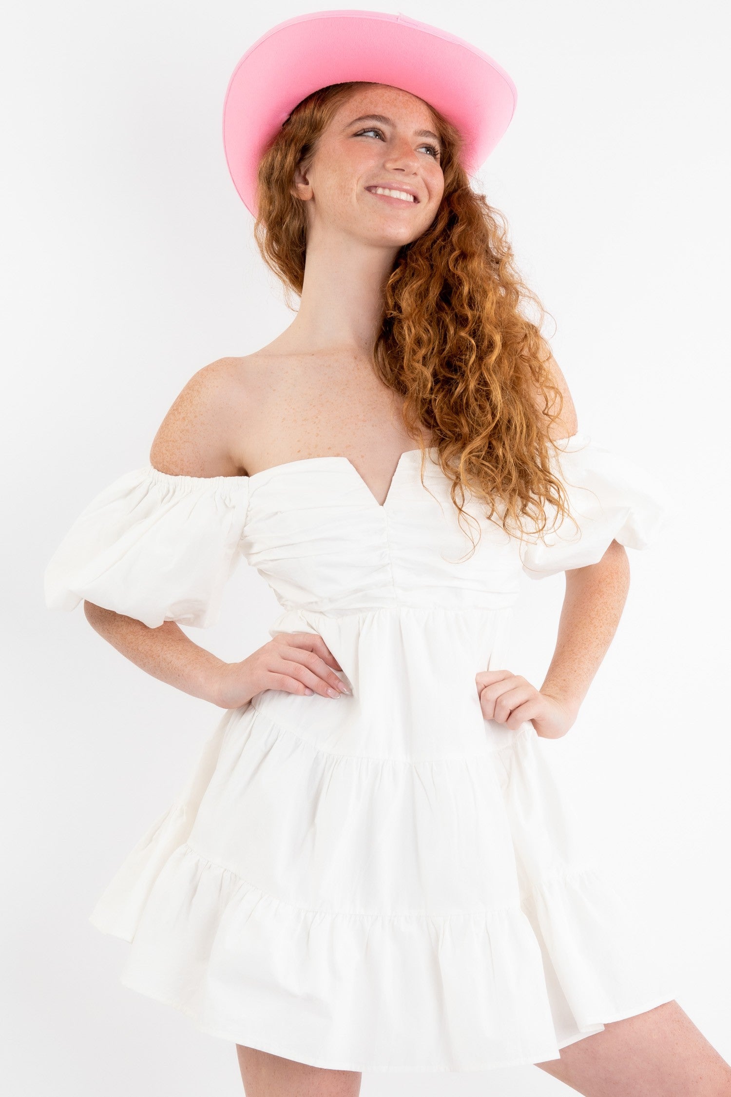 Poplin mini dress in off white featuring a v-trim front and puff sleeves that can be worn on or off the shoulder. Close up view.