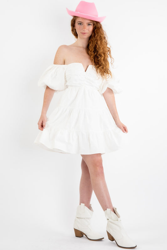 Poplin mini dress in off white featuring a v-trim front and puff sleeves that can be worn on or off the shoulder. Full view.