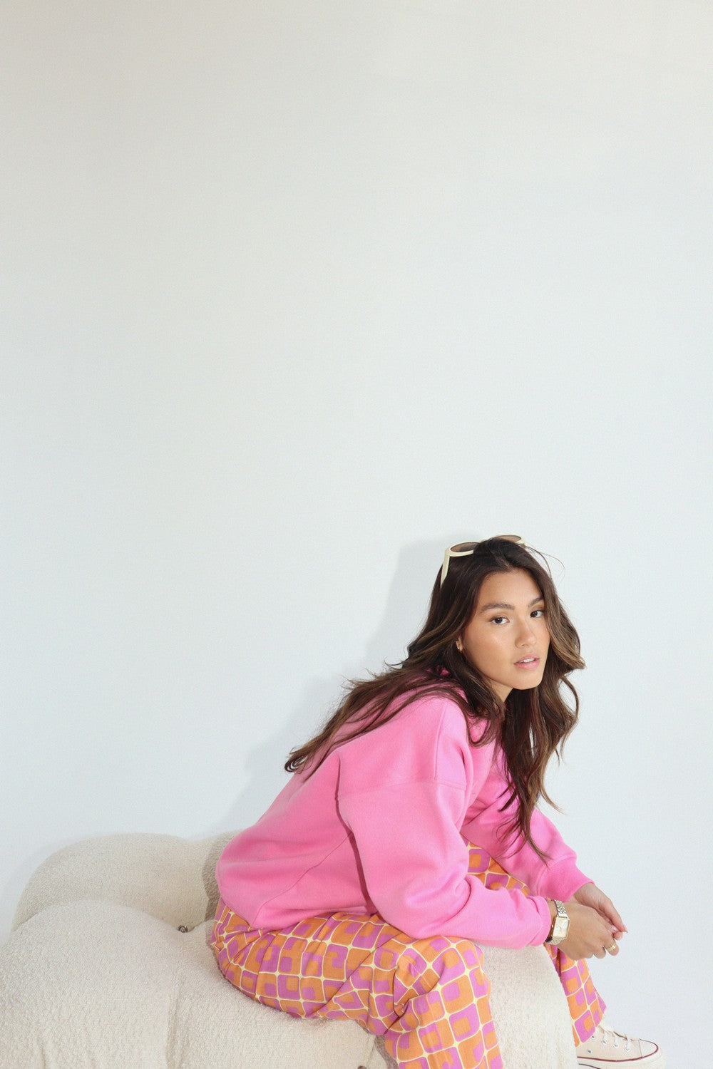 Oversized fleece-lined crewneck sweatshirt in pink.  Embroidered on the front with "Malibu Athletics" and rackets.  Side view.