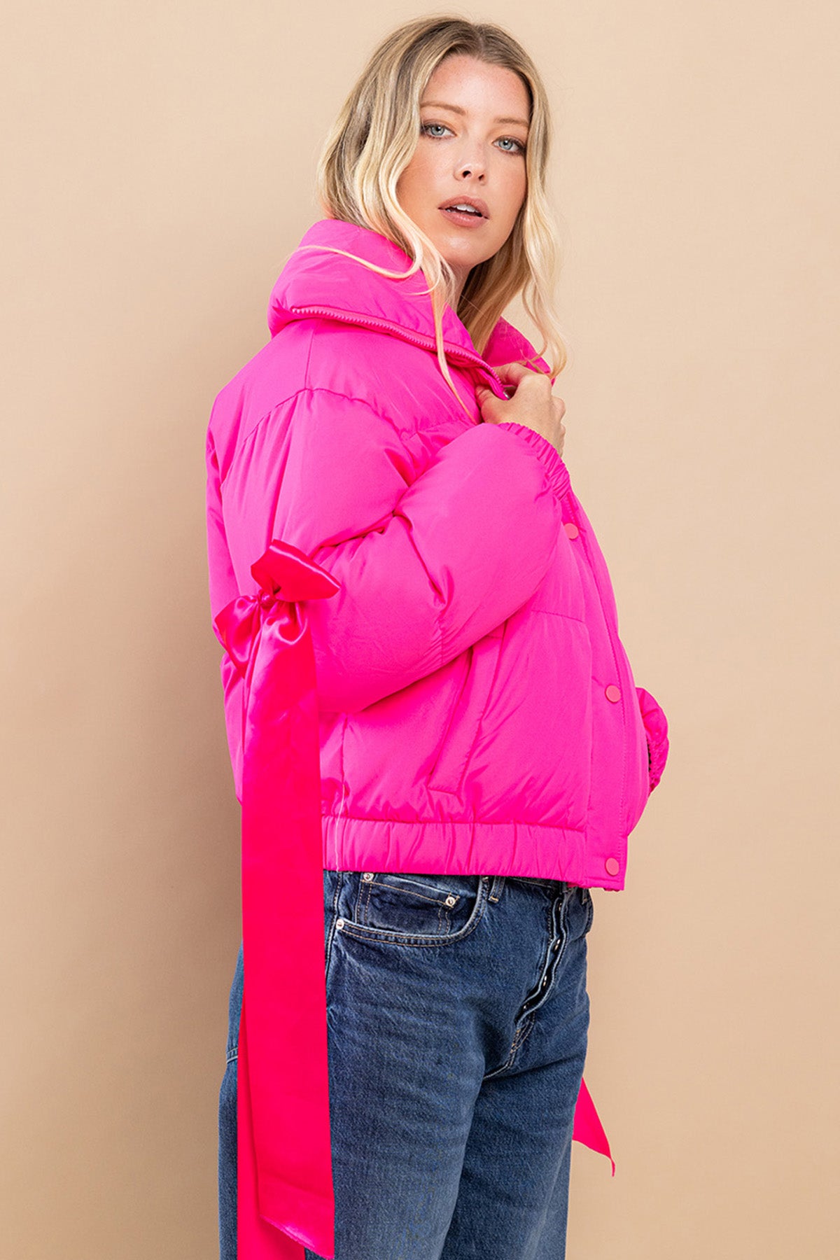 Collared, puffer jacket in fuchsia  with bow knot elbow string.  side view