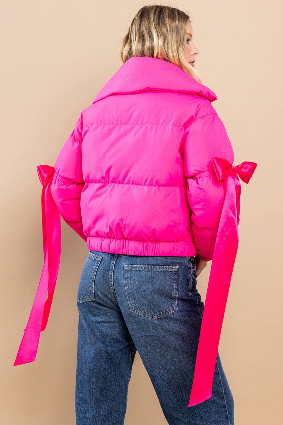 Collared, puffer jacket in fuchsia  with bow knot elbow string.  back view