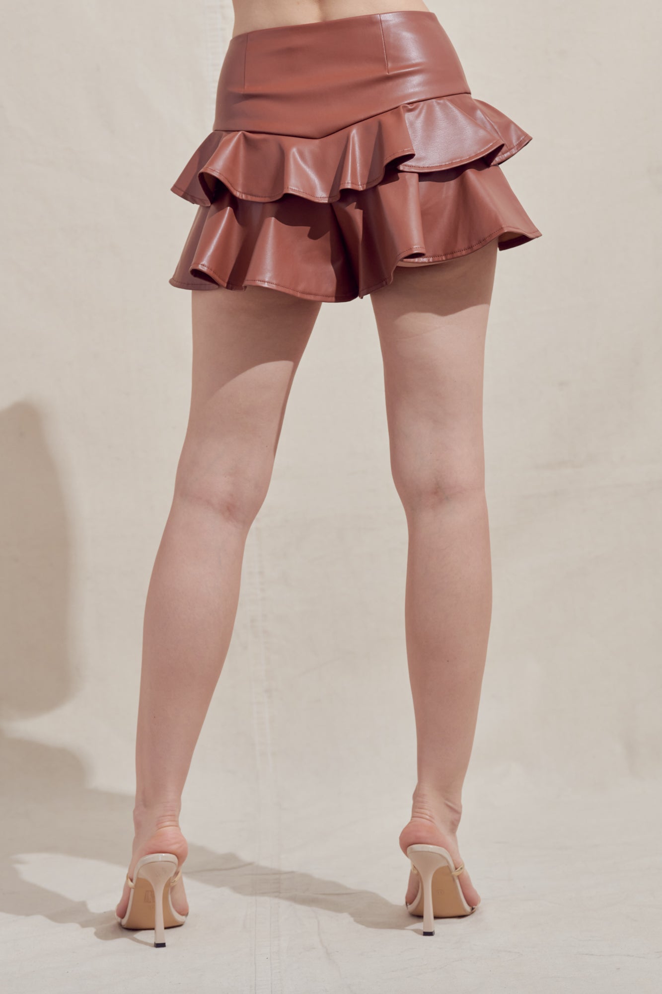 Faux leather two-layered ruffle skort in brown.  Back view.