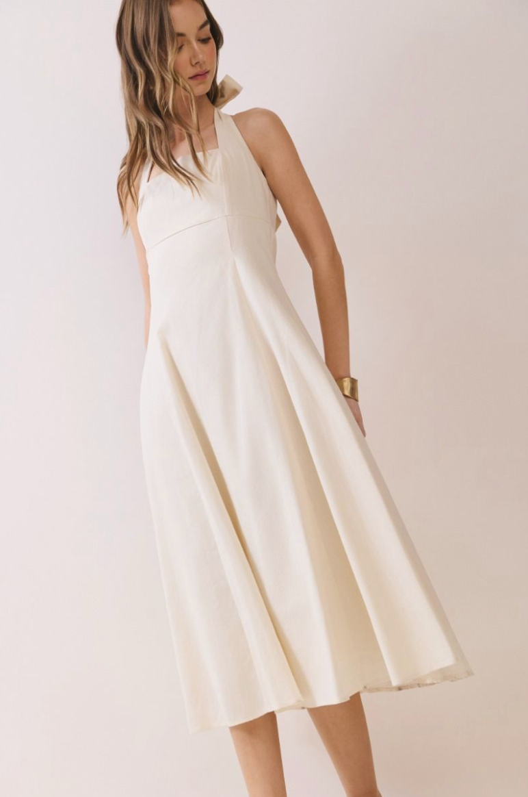 Woman standing in a long cream dress, front view