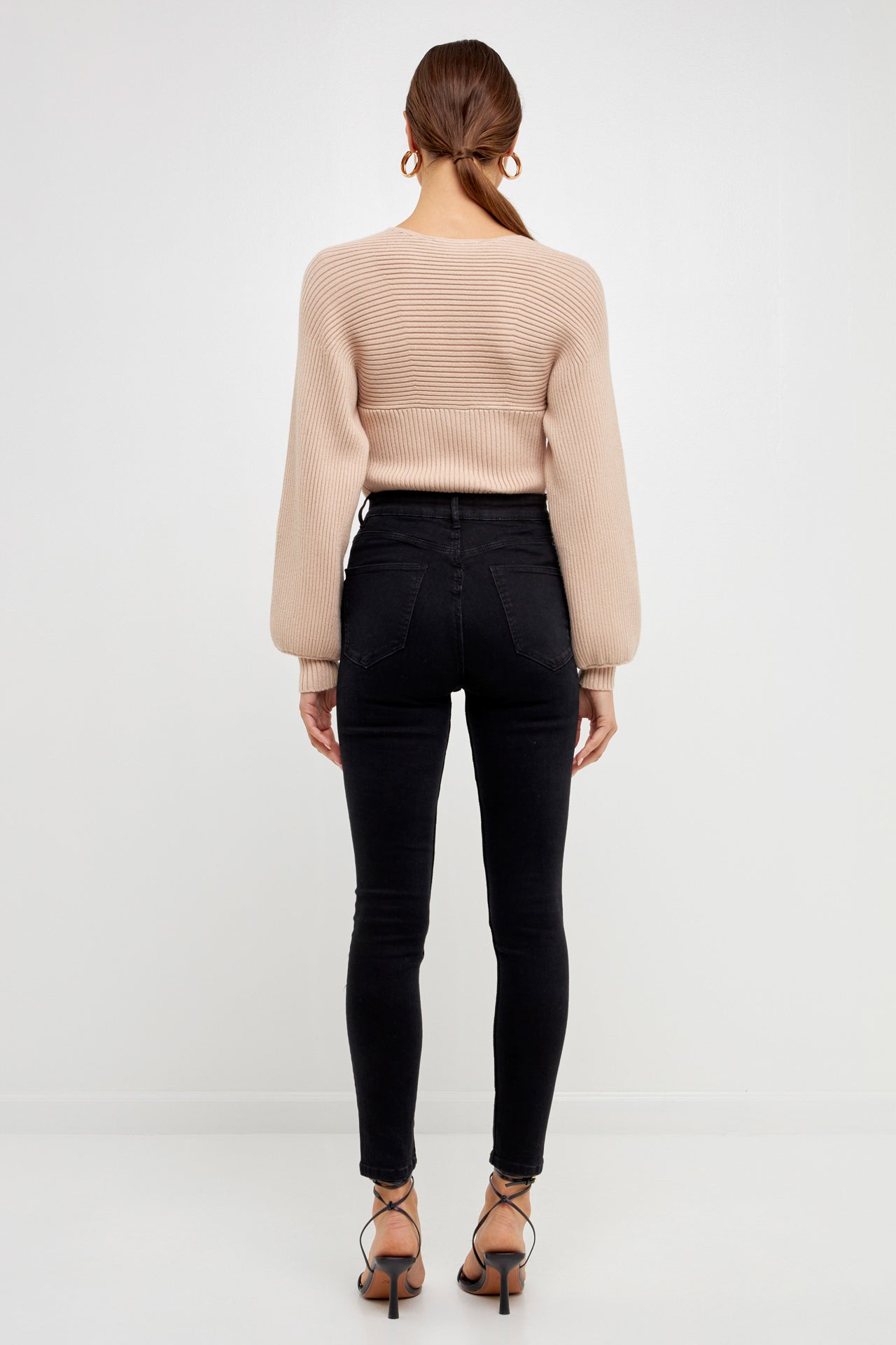 Knitted top in beige featuring square neckline, ribbed detailing, balloon sleeves.  Back full view.