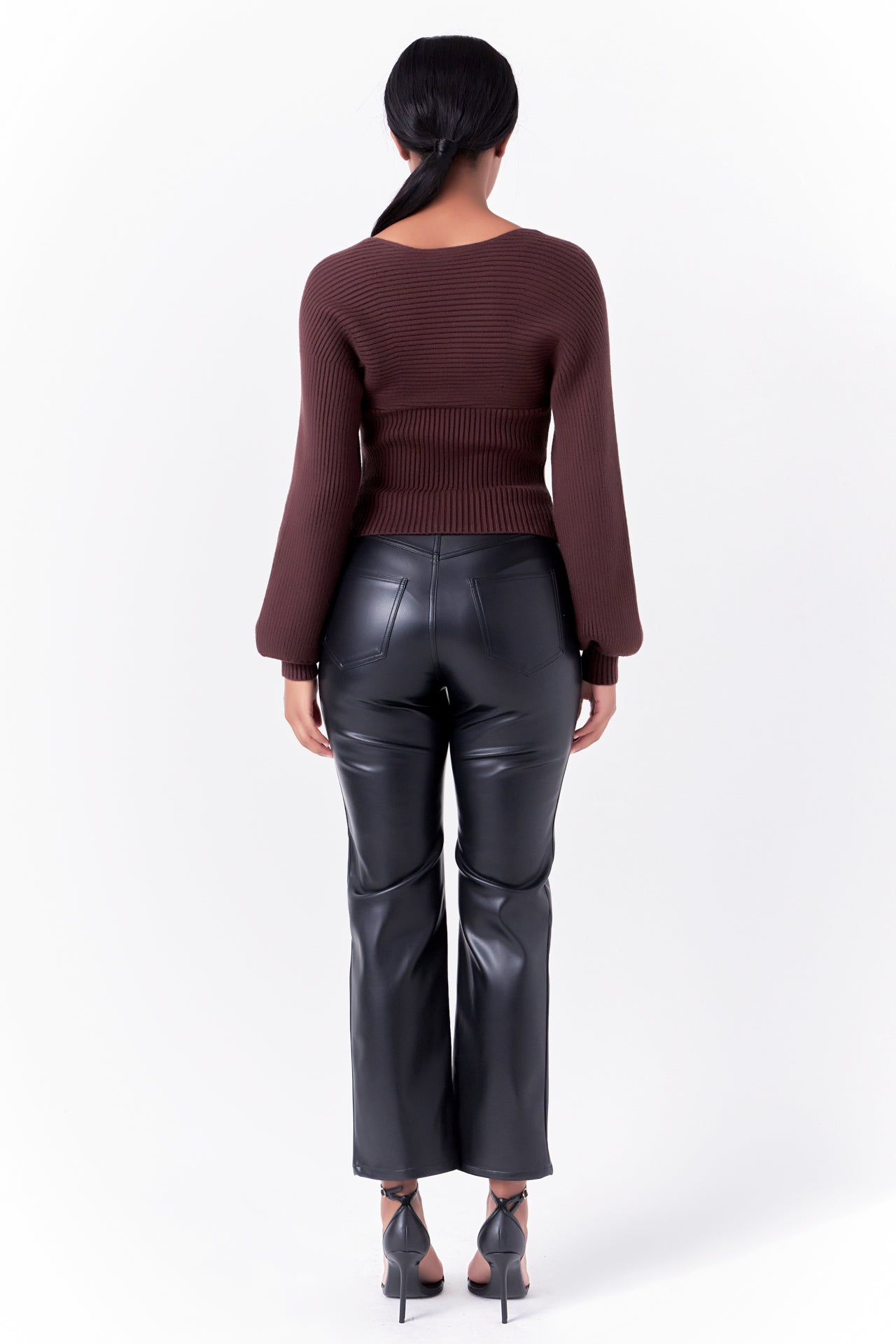 Knitted top in chocolate featuring square neckline, ribbed detailing, balloon sleeves. Back view.