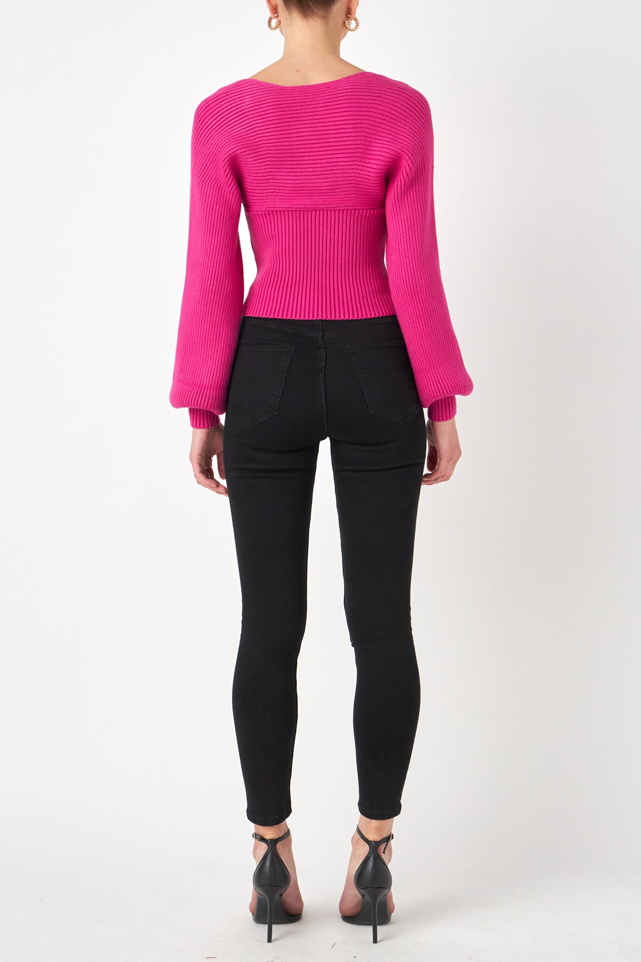 Knitted top in fuchsia featuring square neckline, ribbed detailing, balloon sleeves. Back view.