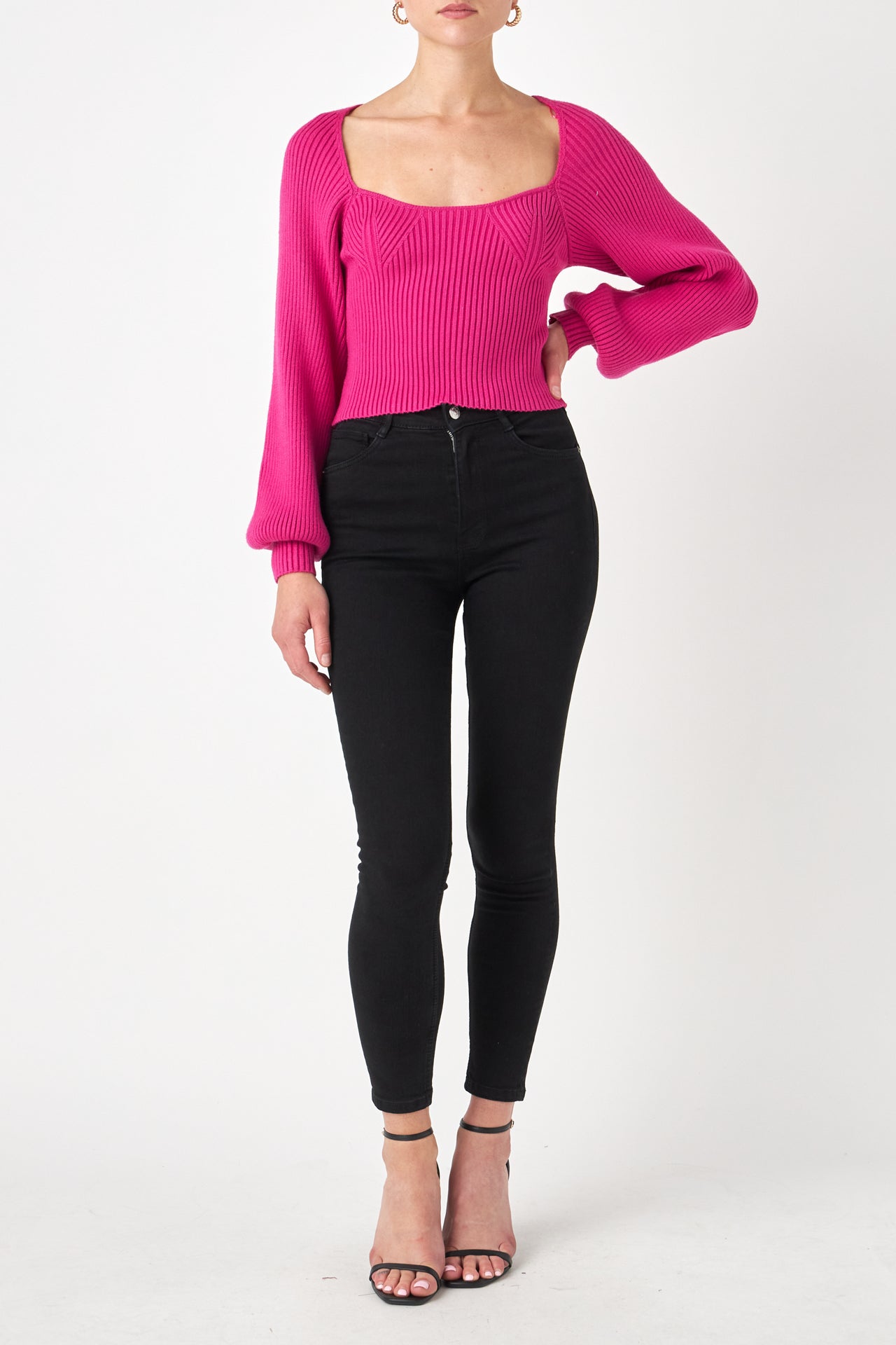 Knitted top in fuchsia featuring square neckline, ribbed detailing, balloon sleeves. Front view.