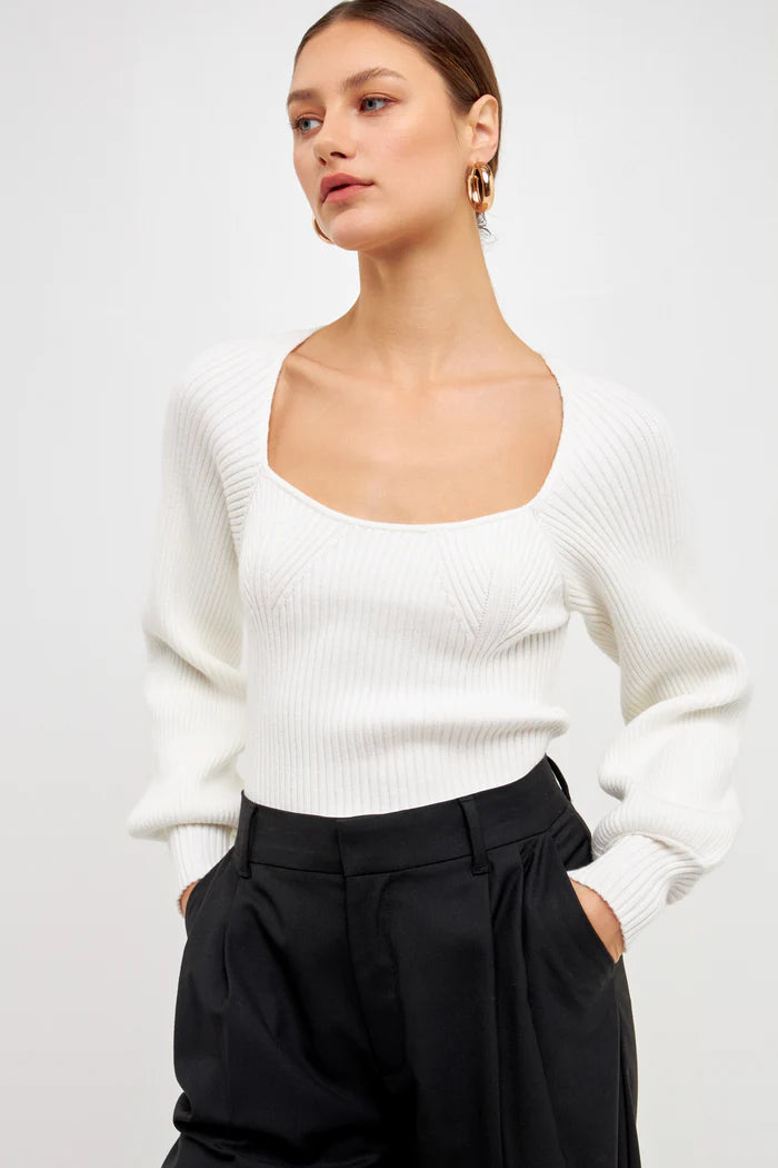 Knitted top in white featuring square neckline, ribbed detailing, balloon sleeves. Front close view.