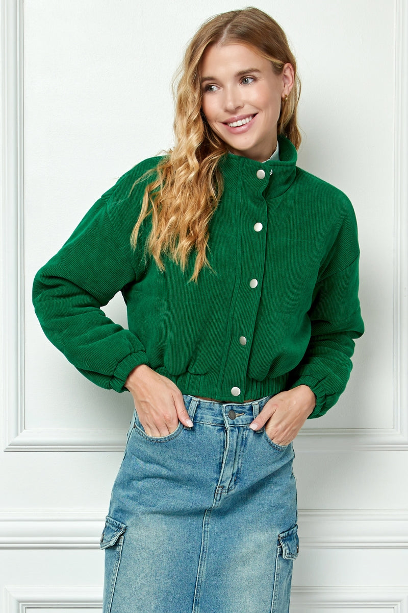 Corduroy short bomber jacket in green featuring button and zippered front closure.  Front closed view.