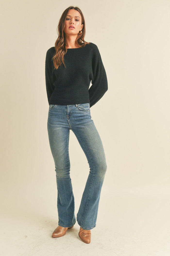 Ribbed sweater in black with long dolman-style sleeves, boat neckline, relaxed bodice, and a fitted waist.  Full view.
