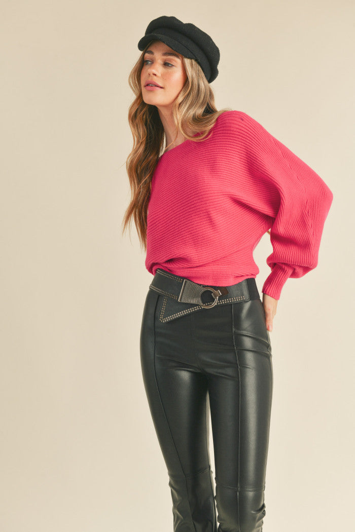 Ribbed sweater in pink with long dolman-style sleeves, boat neckline, relaxed bodice, and a fitted waist.  Full view.