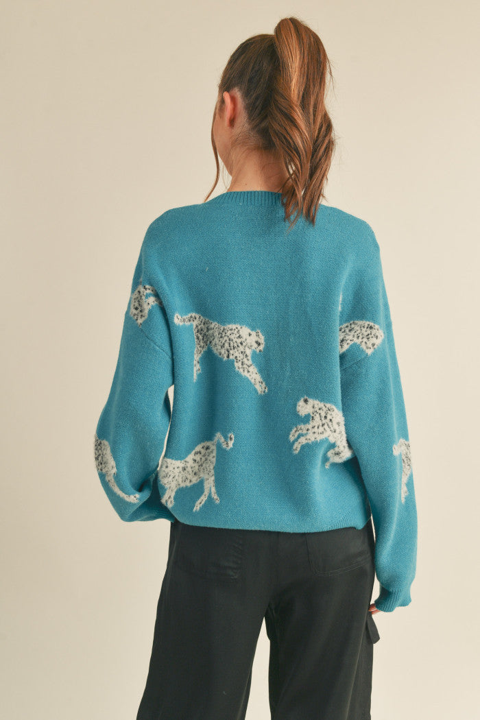 Leopard knit sweater in teal.  Black & white mohair leopard. Ribbed crewneck. Drop shoulder long sleeves. Relaxed fit pullover.  Back view.