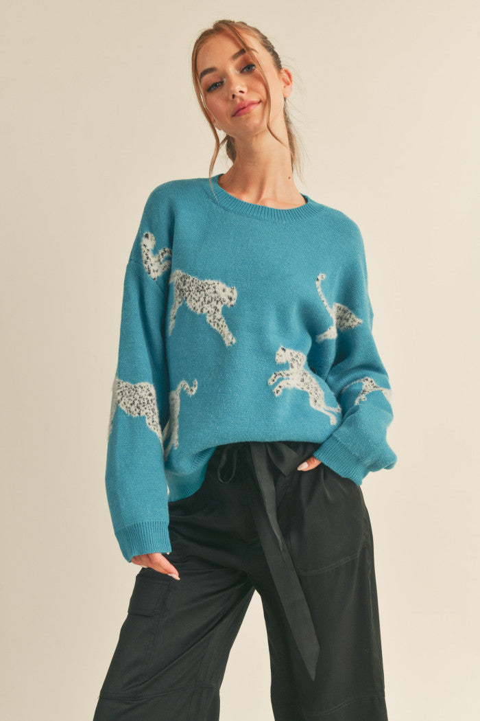 Leopard knit sweater in teal.  Black & white mohair leopard. Ribbed crewneck. Drop shoulder long sleeves. Relaxed fit pullover.  Front view.