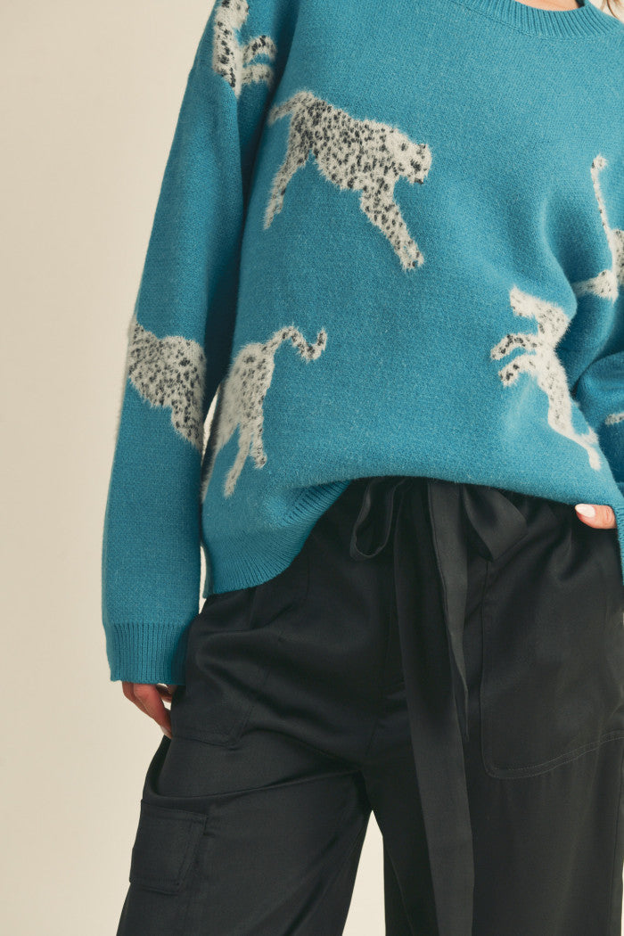 Leopard knit sweater in teal.  Black & white mohair leopard. Ribbed crewneck. Drop shoulder long sleeves. Relaxed fit pullover.  Close up view.